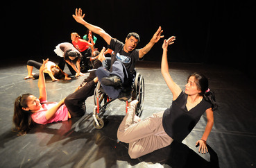 Dancer with cerebral palsy in wheelchair reaching to other dancers Dancer with cerebral palsy in wheelchair reaching to other dancers